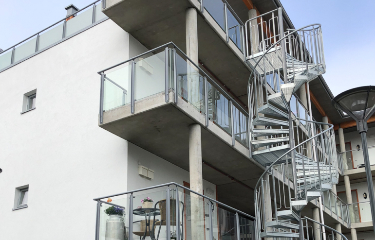 Spiraltrapp i stål utenfor balkonger på leilighetskompleks.